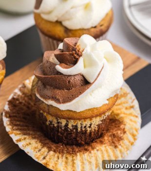 An unwrapped marble cupcake on a wooden surface, showcasing its perfect bake and readiness, with a soft focus on the texture.