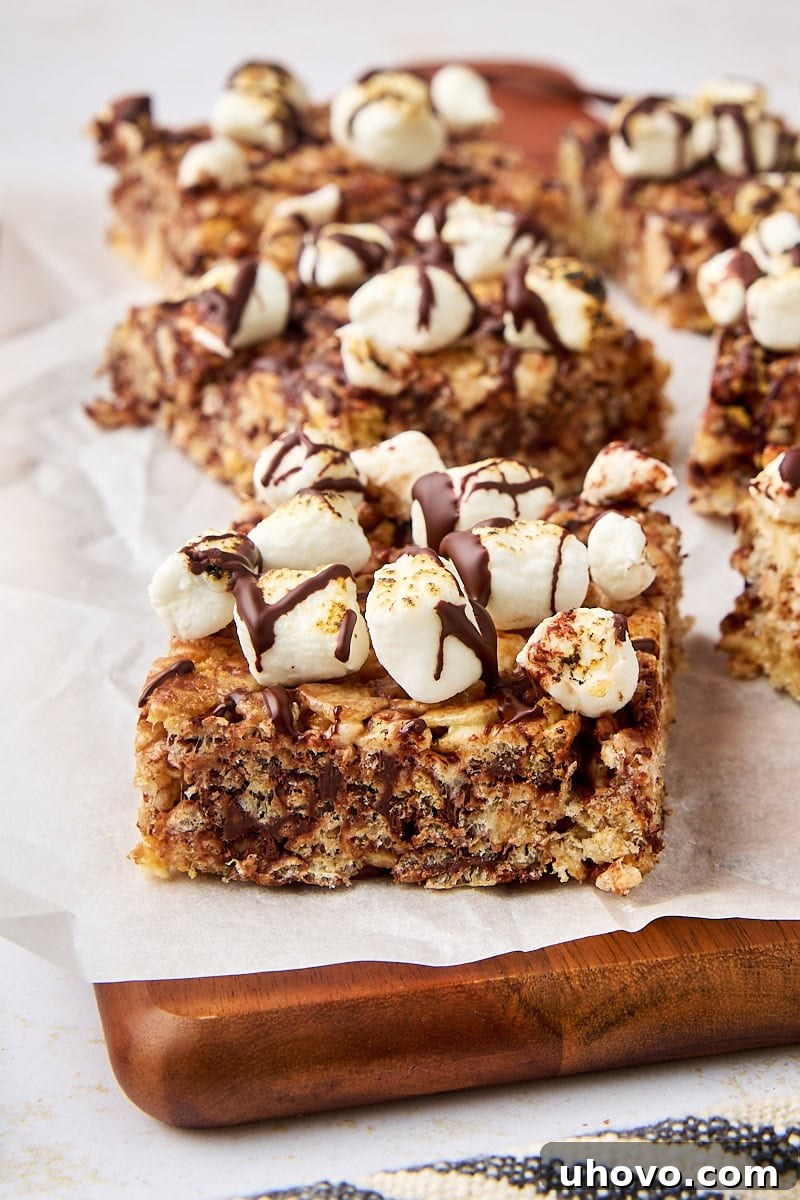 s'mores rice crispy treats on a wooden cutting board lined with parchment paper