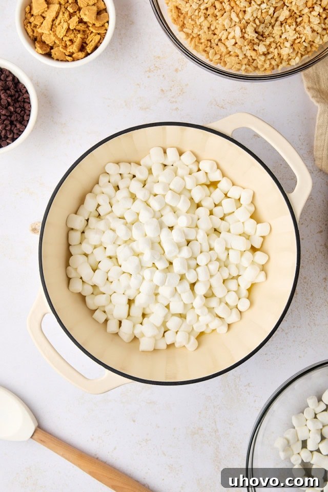 overhead view of mini marshmallows added to melted butter in a saucepan