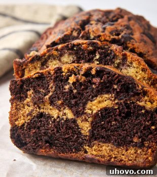 Slices of marbled chocolate banana bread on parchment paper, ready to be enjoyed.