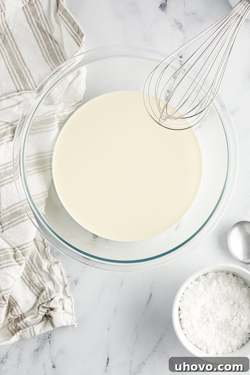 overhead view of heavy cream in a glass mixing bowl