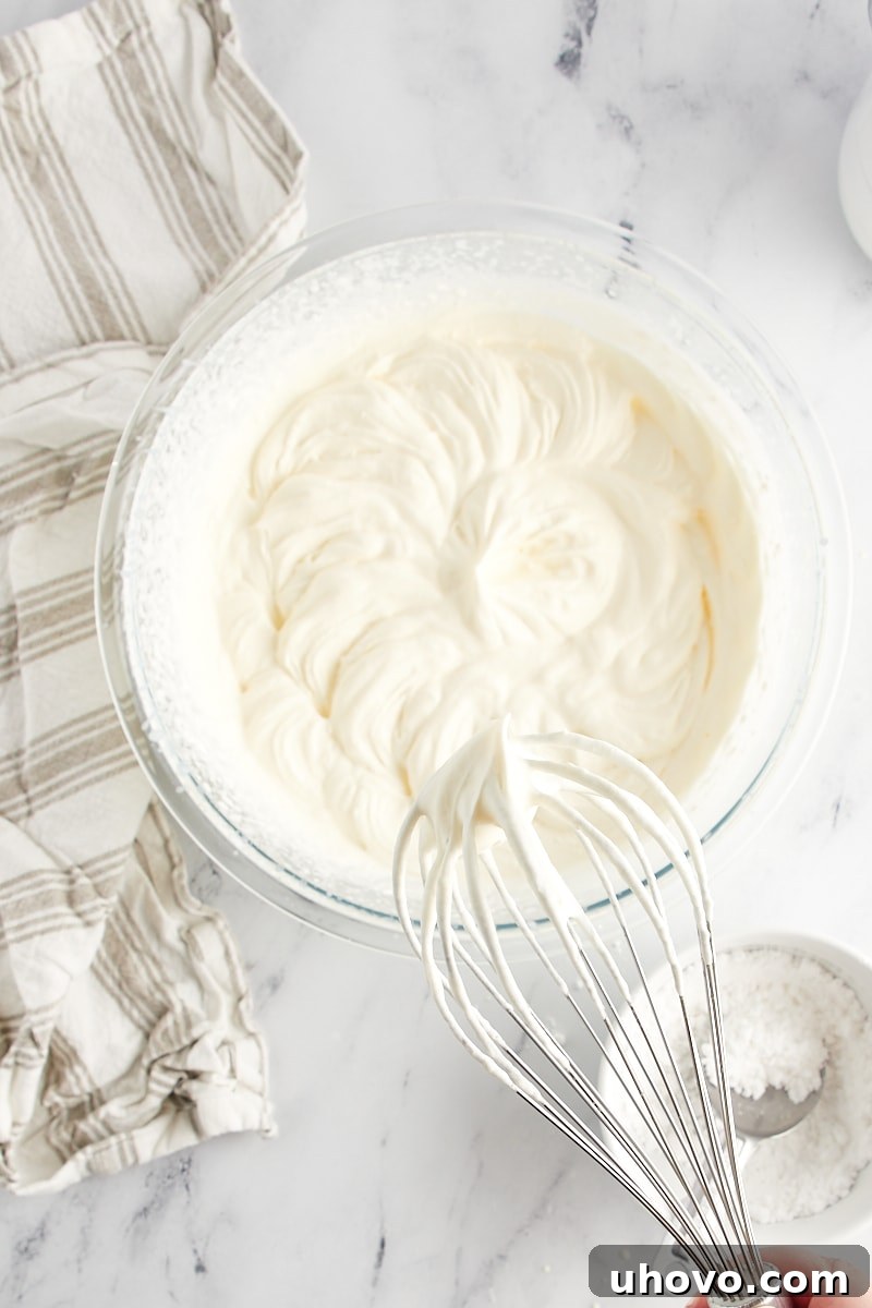 soft-peak whipped cream on a mixer's whisk attachment