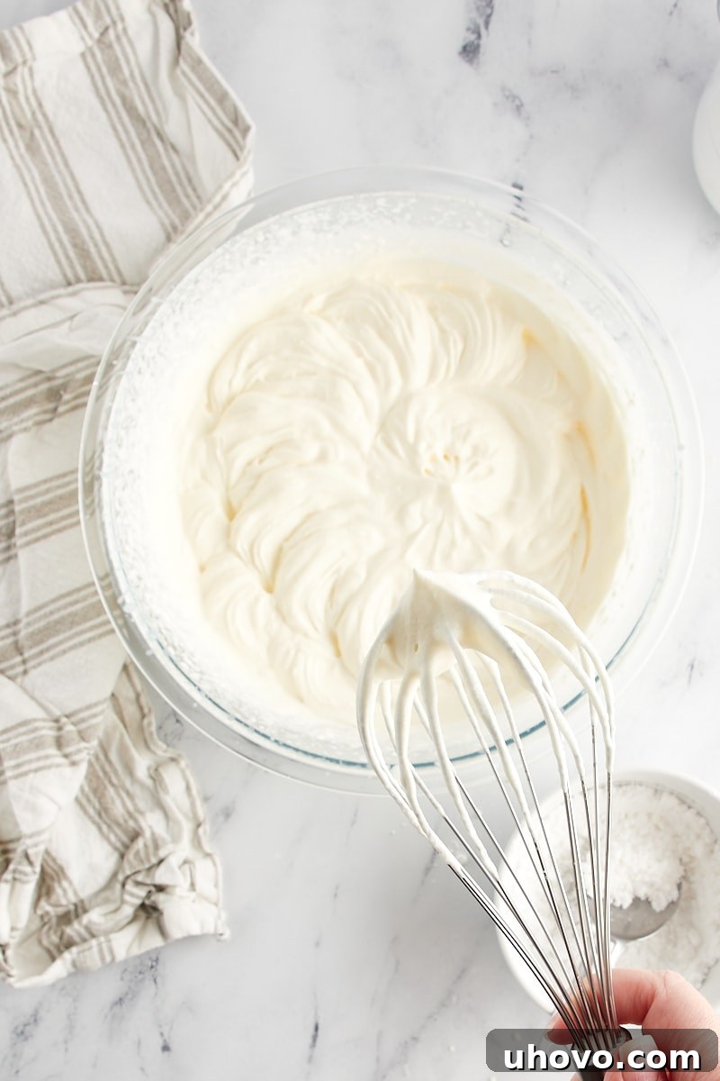 stiff-peak whipped cream on a mixer's whisk attachment
