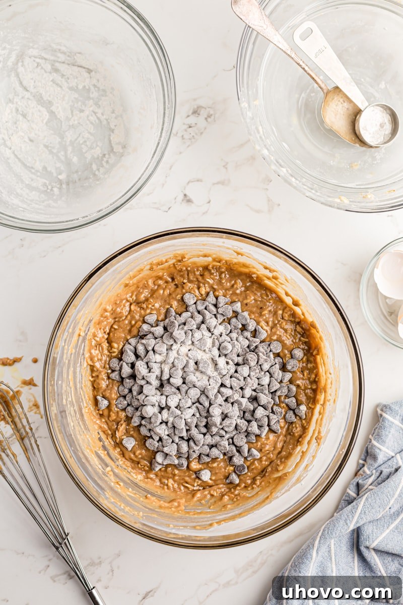 Overhead view of the flour-coated chocolate chips being added to the finished cake batter.