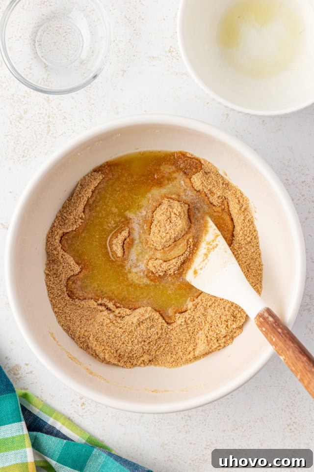 graham cracker crust ingredients being mixed together in a white bowl
