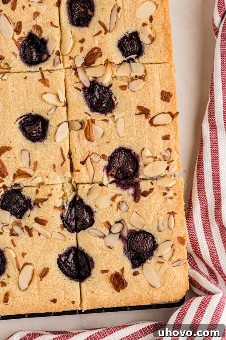 Overhead view of cherry almond sheet cake cut into pieces