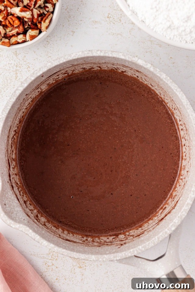 Unsalted butter, cocoa powder, and milk are gently heated in a saucepan, forming the smooth and rich base for the fudgy frosting.