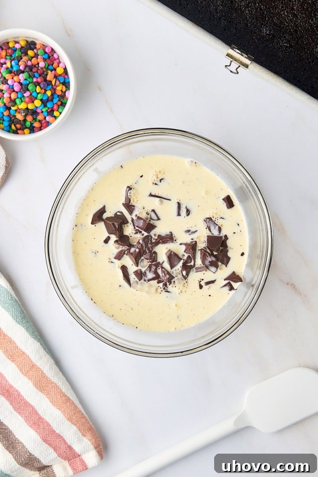 overhead view of cream poured over chopped semisweet chocolate in a glass bowl