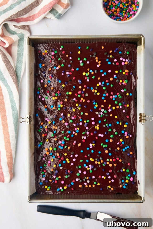 overhead view of cosmic brownies topped with ganache and rainbow chips in a 9x13 pan