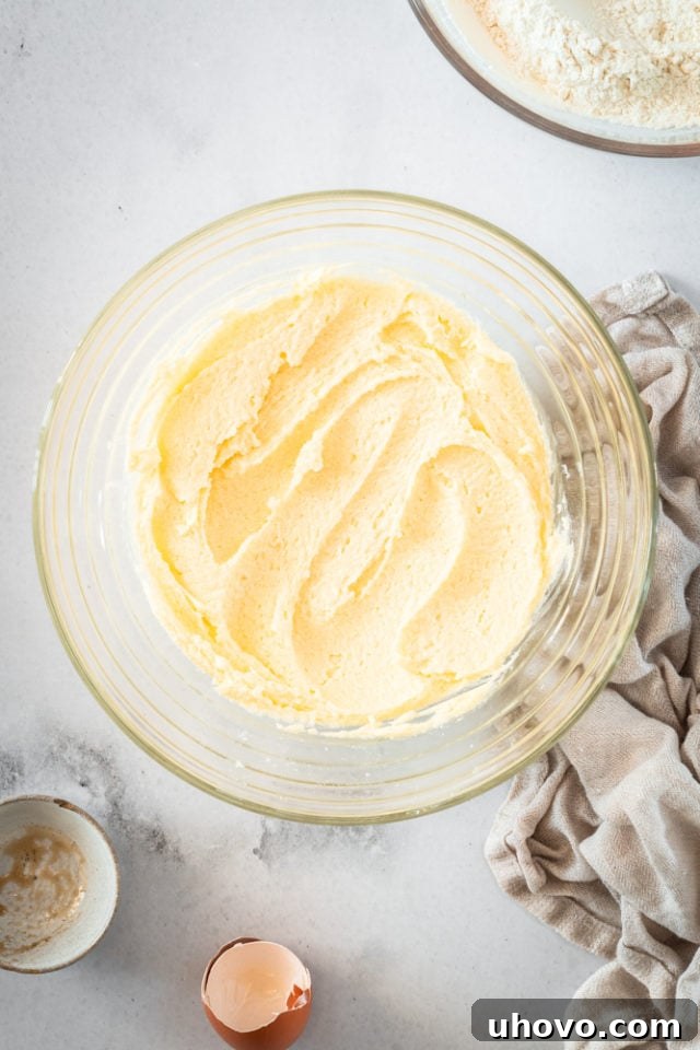 Creamed butter and sugar in a glass bowl, appearing light and fluffy after being beaten.