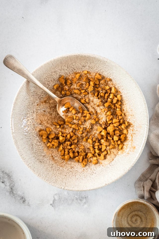 Pecan and cinnamon sugar filling for cookies in a bowl with a spoon, showing its granular texture.