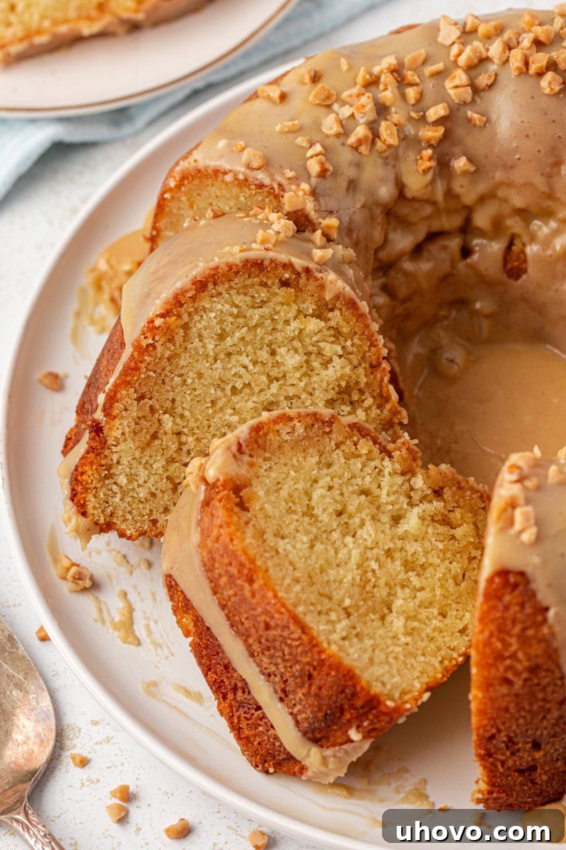partially sliced caramel swirl Bundt cake on a white cake plate