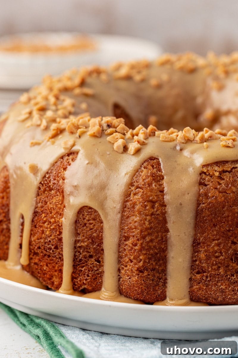 caramel swirl Bundt cake topped with caramel glaze on a white cake plate
