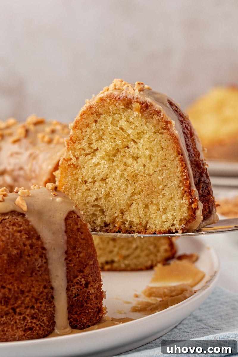 a slice of caramel swirl Bundt cake being lifted away from the remaining cake