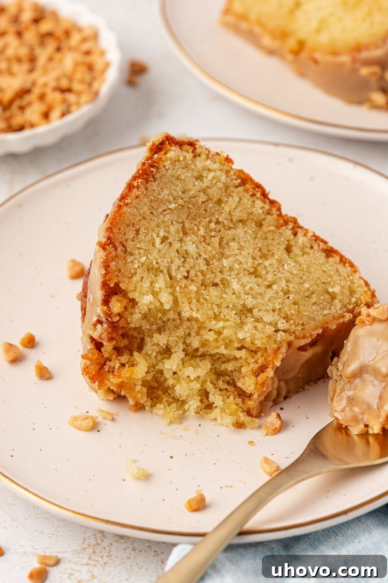 a slice of caramel swirl Bundt cake on a white plate with a bite on a fork