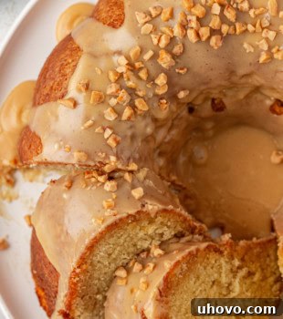 partially sliced caramel swirl Bundt cake on a white cake plate