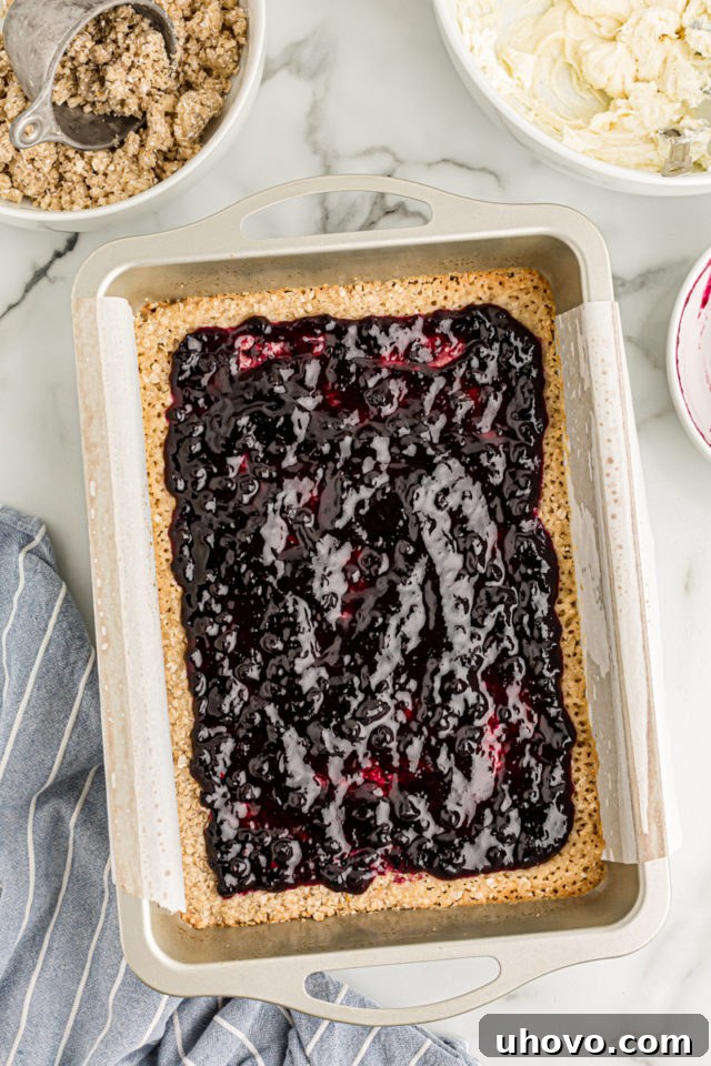 Overhead view of blueberry jam spread over crust in pan