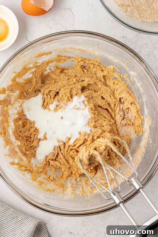 overhead view of buttermilk added to s'mores whoopie pie batter in a glass mixing bowl