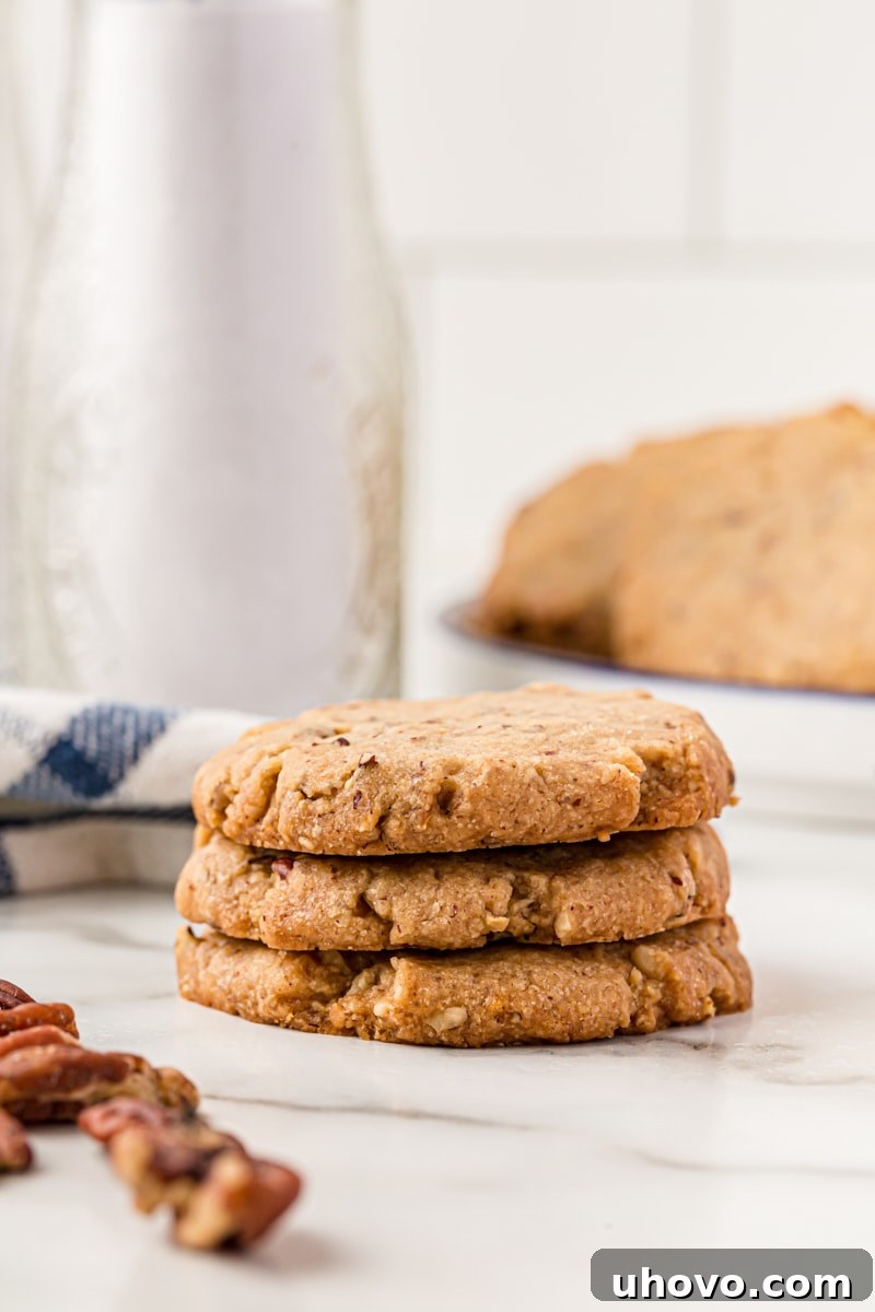 Stack of 3 pecan sandies cookies, showcasing their inviting texture and golden hue. These classic pecan cookies practically melt in your mouth!