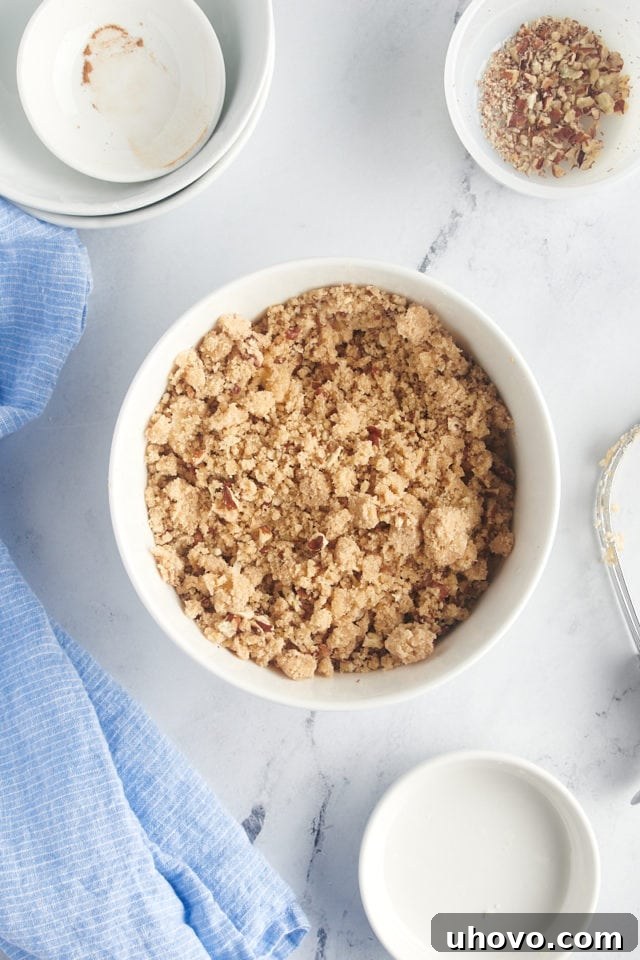 Overhead view of the crumbly topping mixture, including flour, sugar, cinnamon, and cut butter, in a bowl.