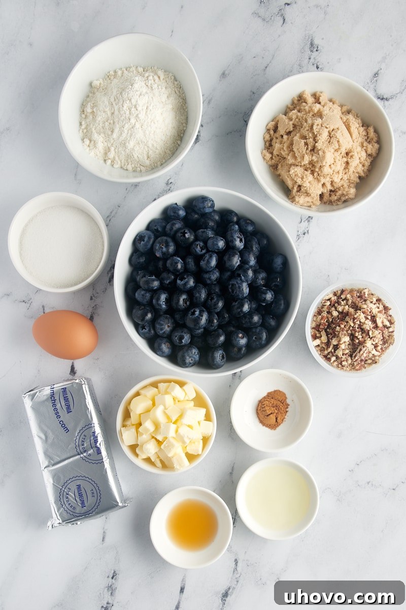 Overhead view of fresh ingredients for blueberry crisp, including cream cheese, blueberries, butter, and flour.