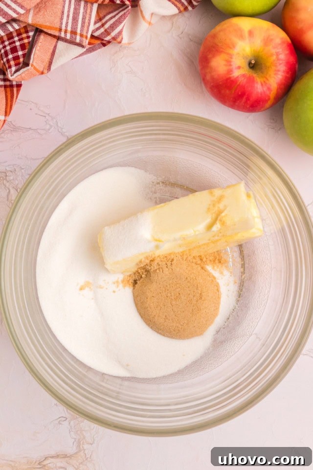overhead view of butter, sugar, and brown sugar in a glass mixing bowl