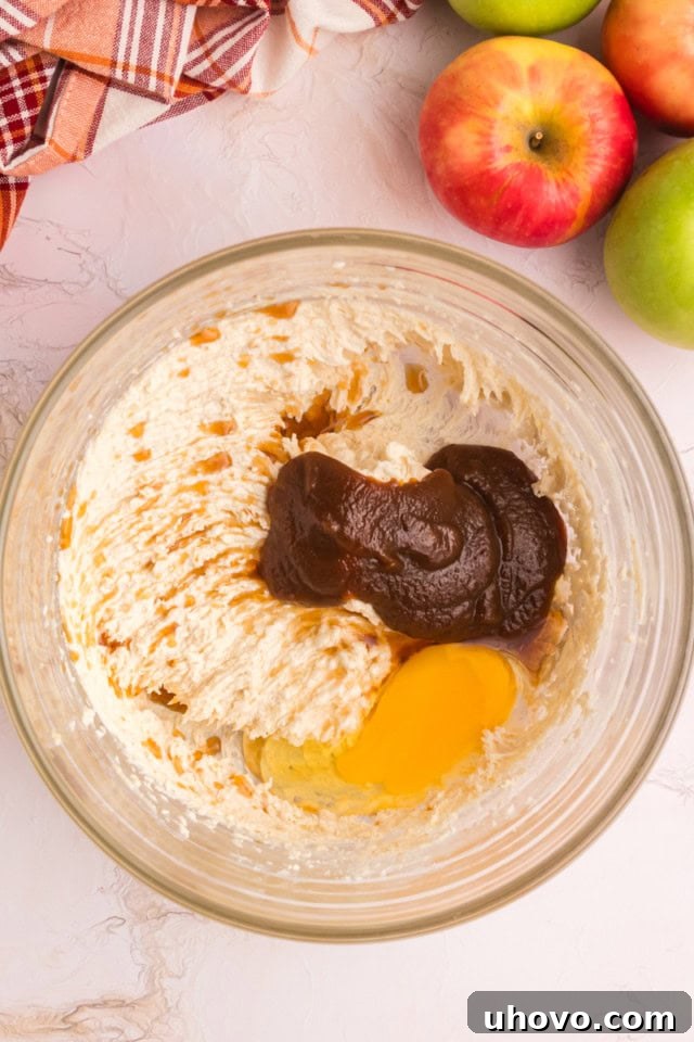 overhead view of apple butter, egg, and vanilla added to creamed butter and sugar