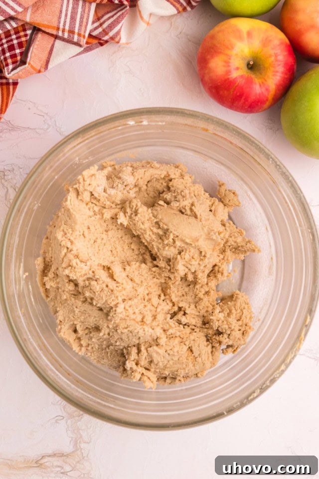 overhead view of apple butter snickerdoodle cookie dough in a glass mixing bowl