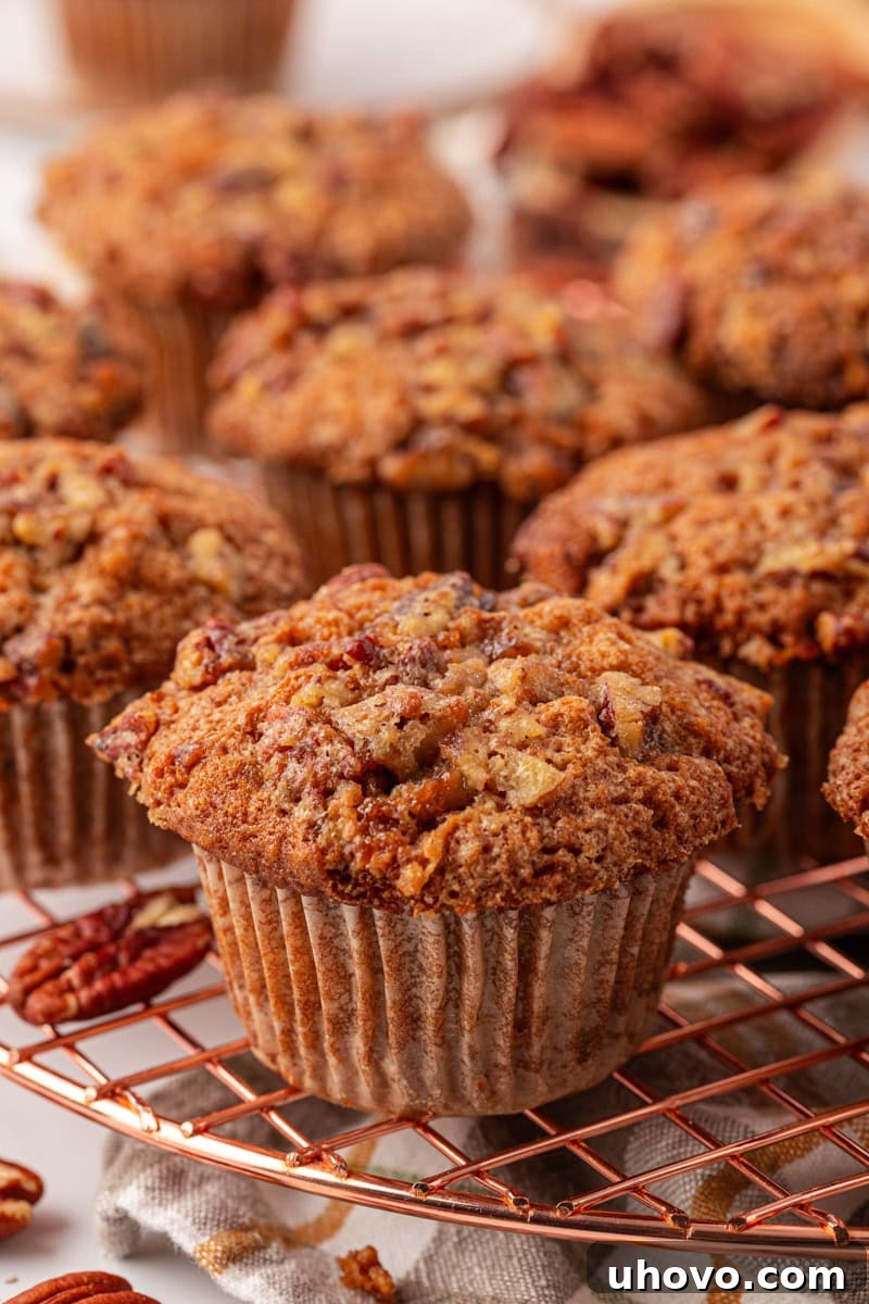 close-up of a pecan praline muffin on a wire rack with more muffins in the background