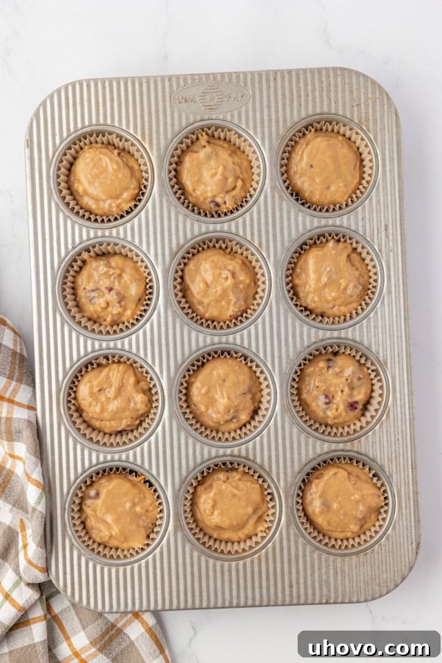 overhead view of pecan praline muffin batter divided into a 12-cup muffin pan