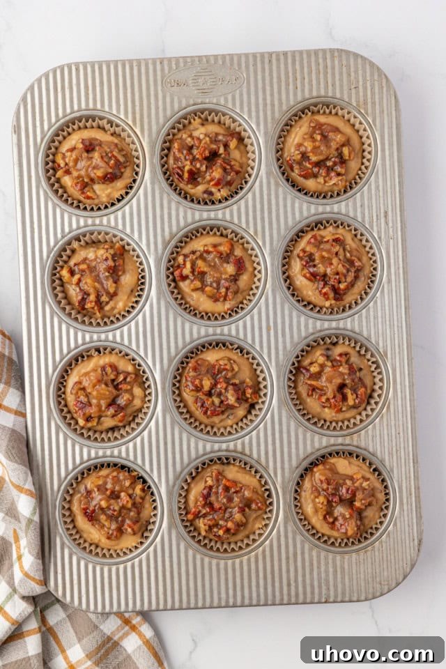 overhead view of pecan praline muffins in a muffin pan ready to go into the oven