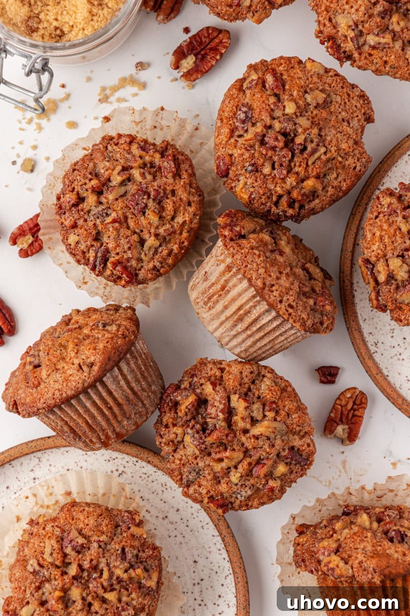 overhead view of several pecan praline muffins scattered on a white surface