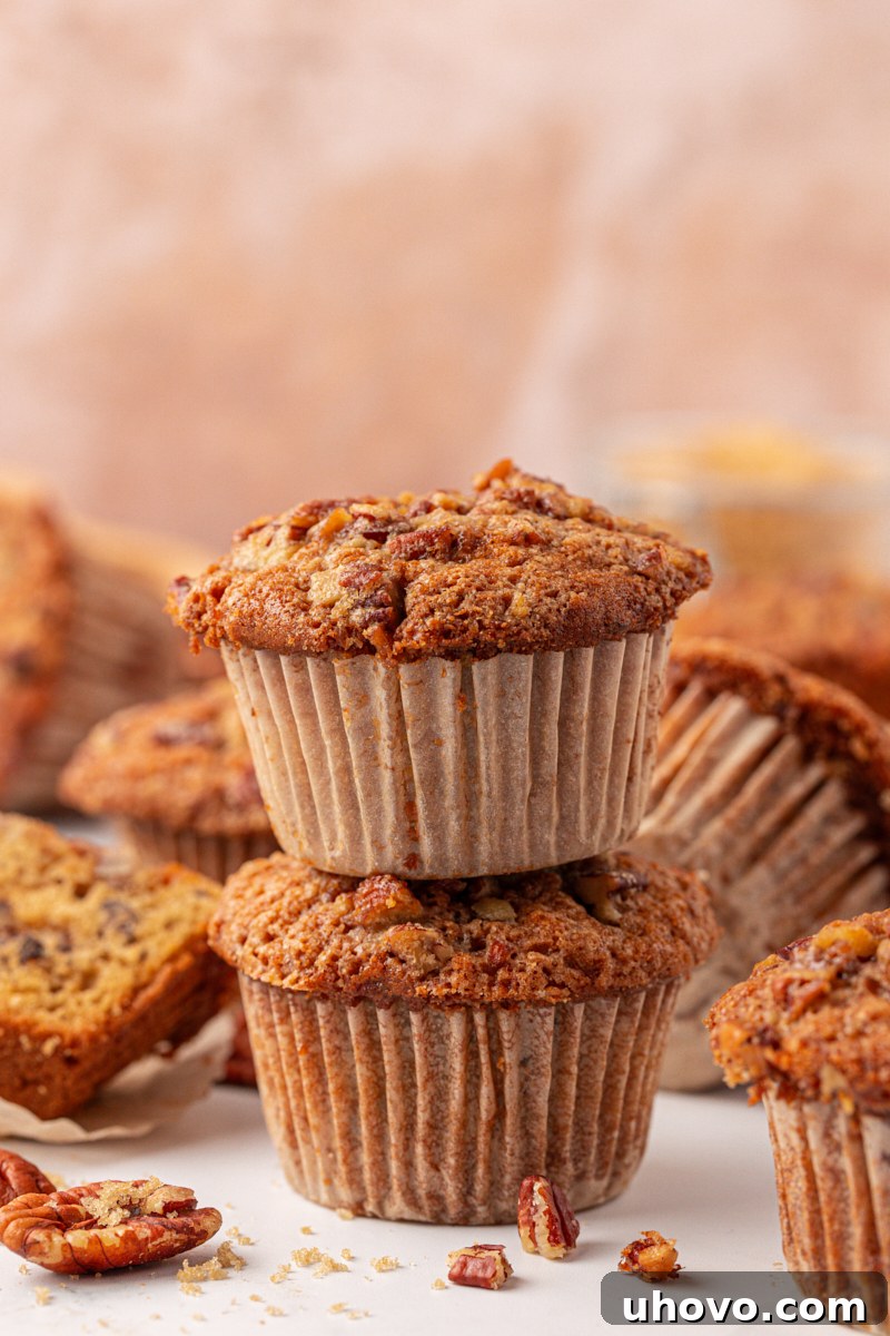 two stacked pecan praline muffins with more muffins in the background