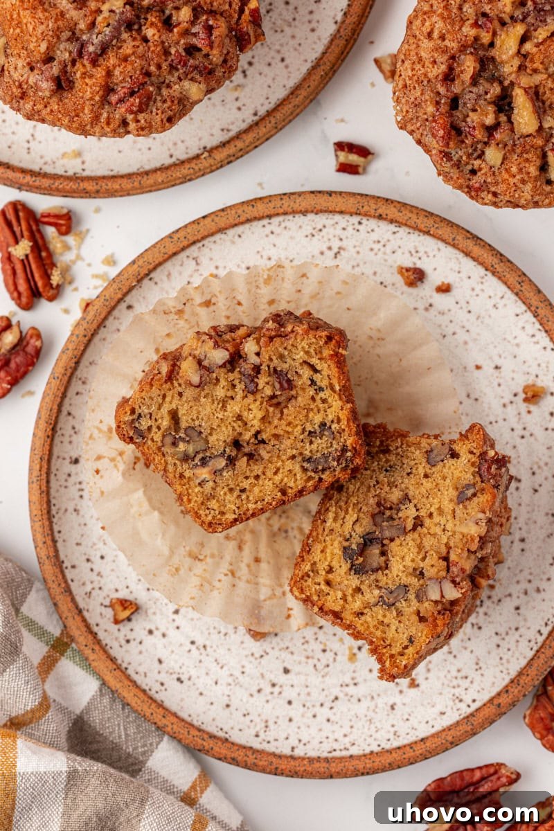 overhead view of a pecan praline muffin cut in half on a brown-rimmed white plate