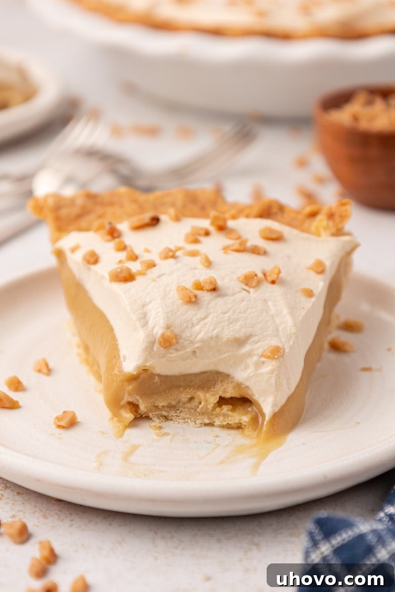 a slice of butterscotch pie with a bite missing on a white plate