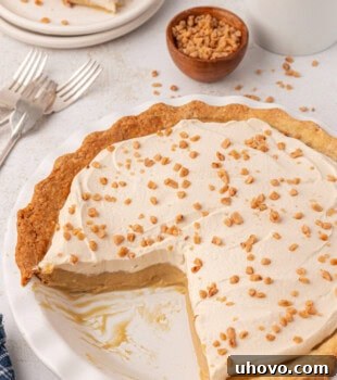 partially sliced butterscotch pie in a white pie plate