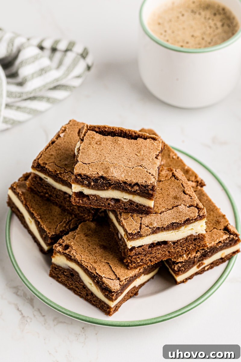 Pile of Irish cream brownies with cream cheese visible on a white plate, ready to be served.