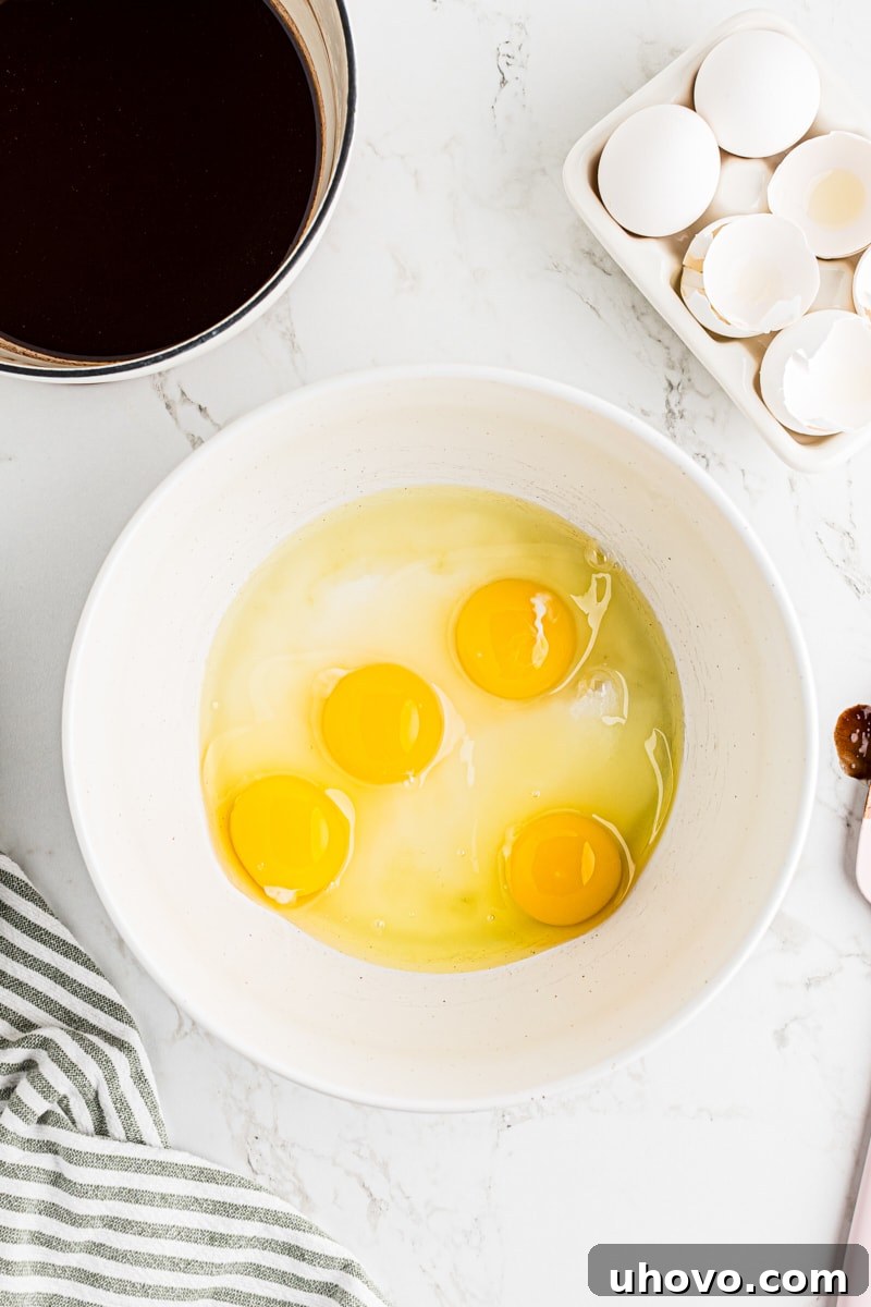 Overhead view of eggs and sugar in mixing bowl, light and fluffy.