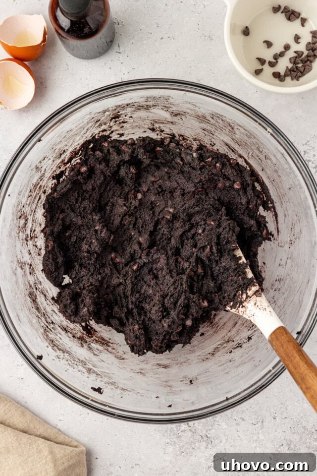 overhead view of black cocoa cookie dough in a glass mixing bowl