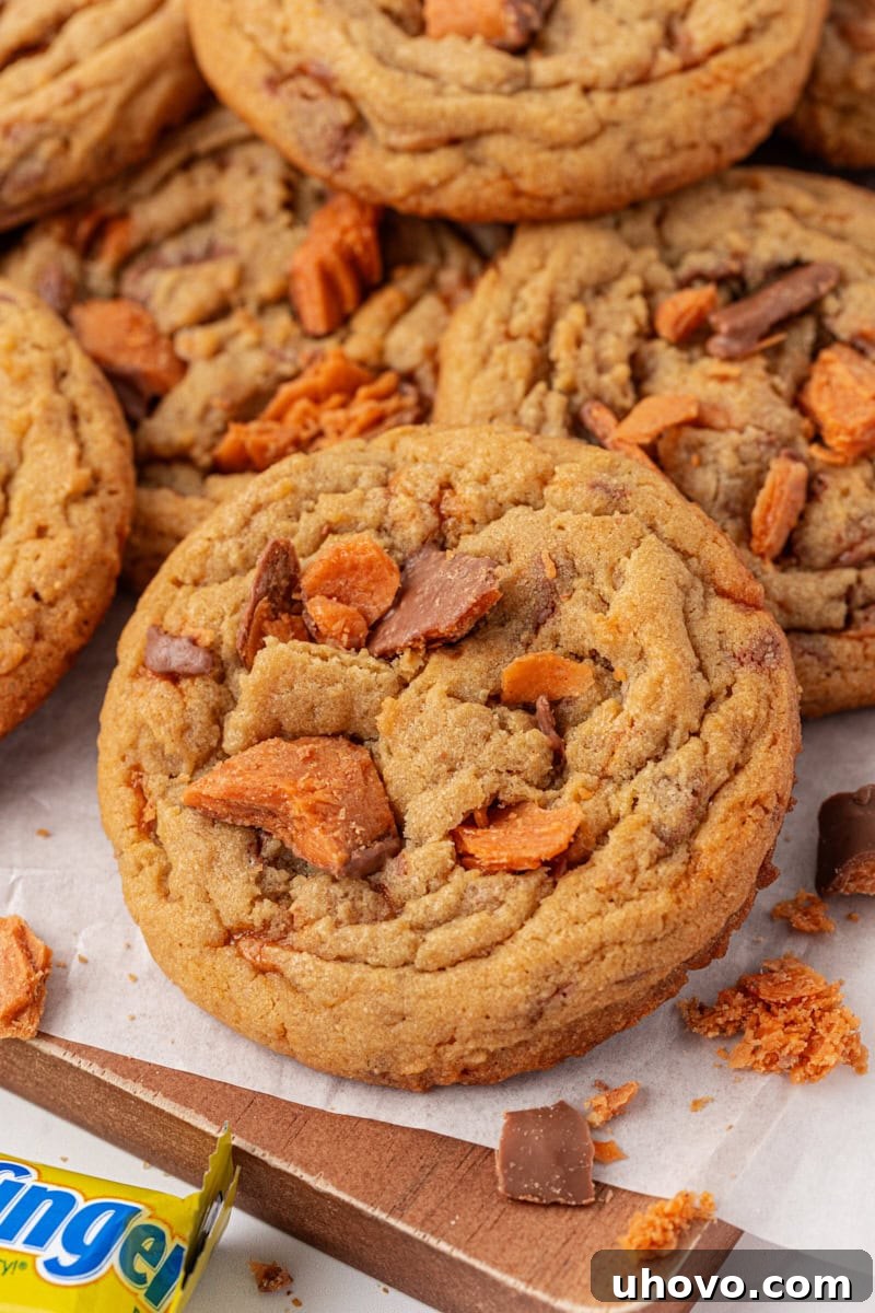 Butterfinger cookies piled on a parchment-lined wooden serving board