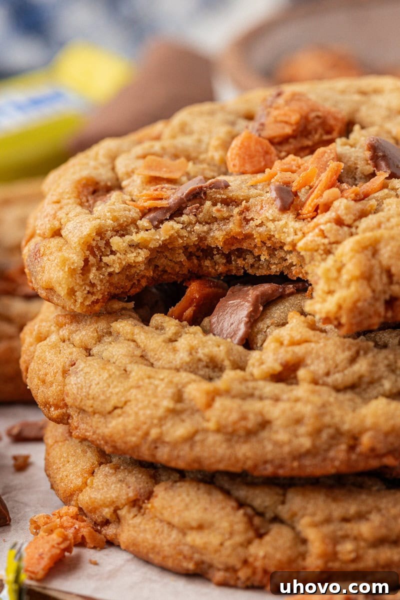 close up view of a stack of three Butterfinger cookies with a bite missing from the top cookie