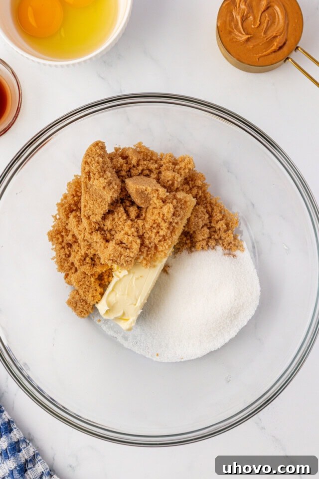 overhead view of butter, sugar, and brown sugar in a glass mixing bowl