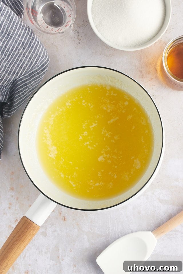 Overhead view of butter and water simmering in a saucepan for the rum glaze.
