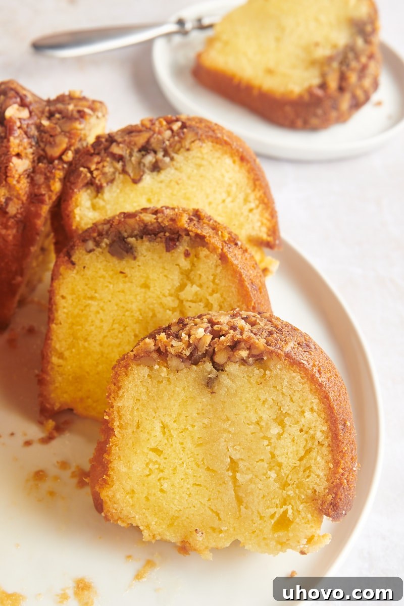 Rum cake slices artfully arranged on a serving platter, showcasing their moist texture and pecan topping.
