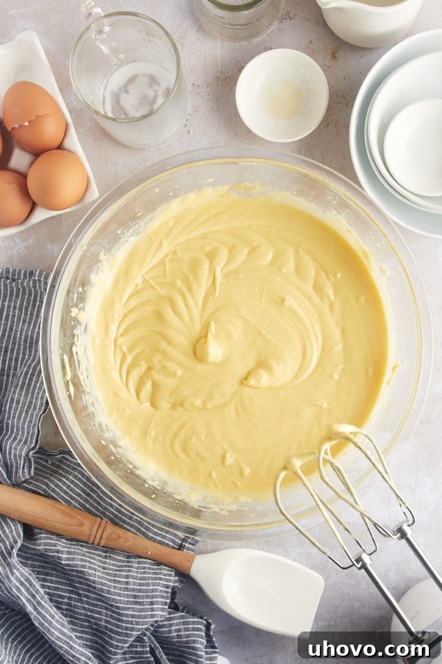 Overhead view of smooth, thick rum cake batter in a glass mixing bowl, ready to be poured.