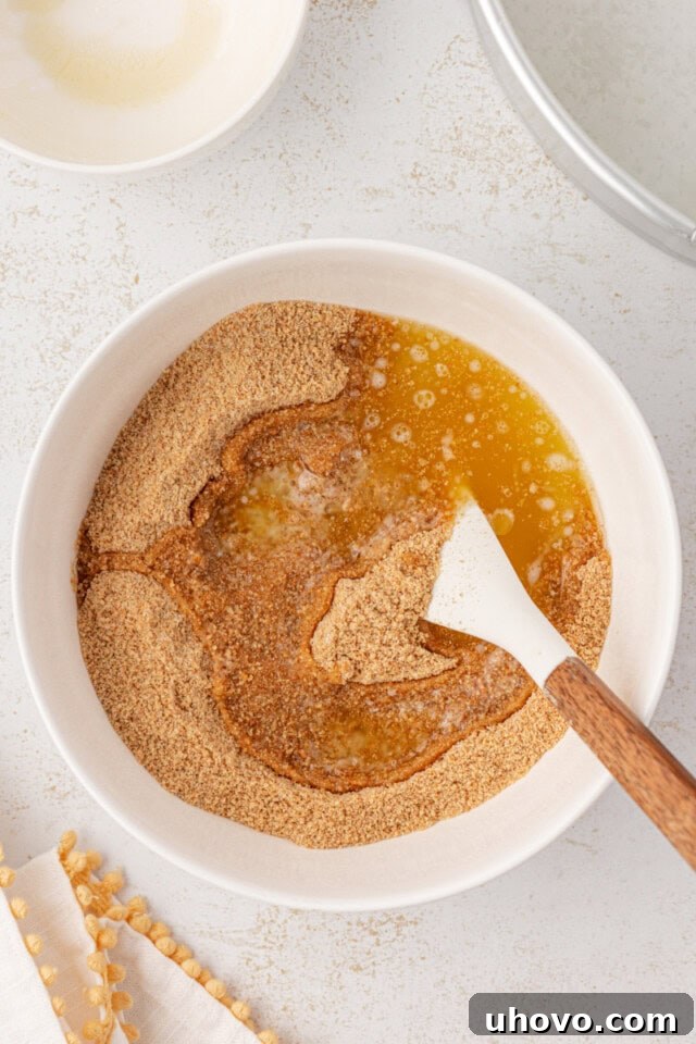 overhead view of melted butter added to graham cracker crust mixture