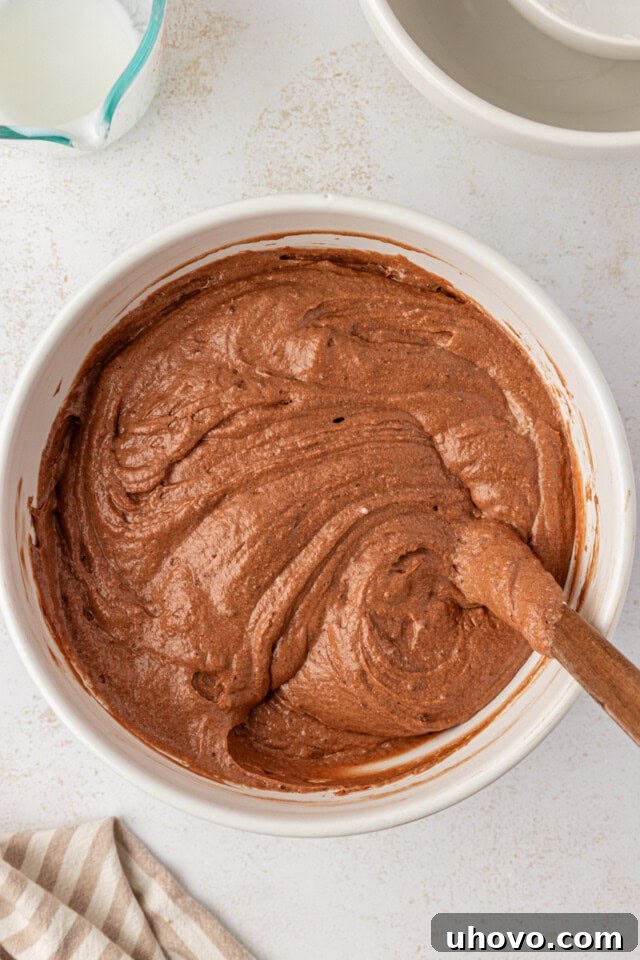 Overhead view of the fully mixed German chocolate cake batter in a white mixing bowl, now light and airy after folding in egg whites.