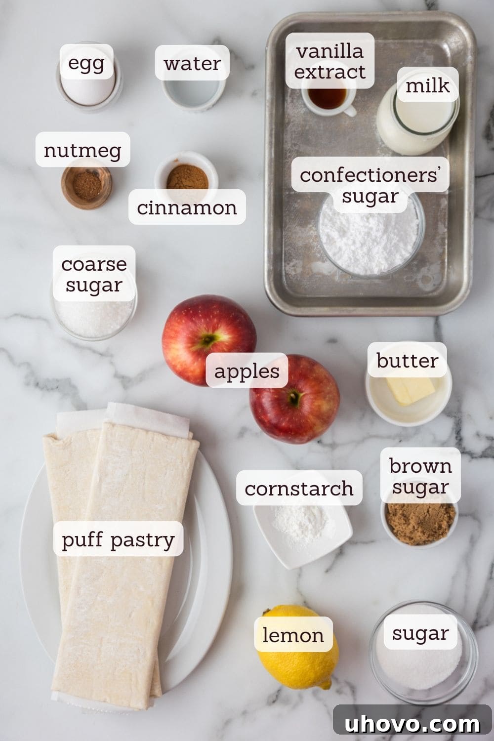 Overhead view of all key ingredients for making apple turnovers neatly arranged on a counter.