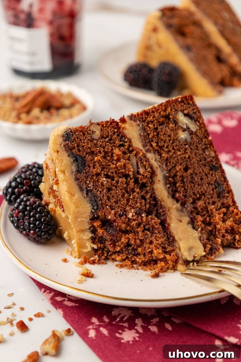 a slice of Kentucky jam cake on a white plate with a bite missing; more cake, jam, and nuts partially visible in the background. This cozy Southern jam cake is moist, spiced, and topped with creamy caramel frosting. A must-bake for winter!