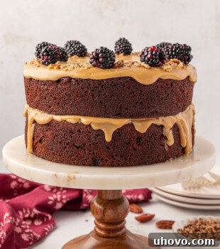 Kentucky jam cake topped with fresh blackberries and chopped nuts served on a marble cake stand